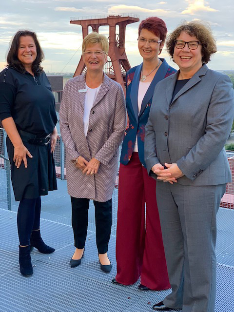 Foto von vier Frauen in Businesskleidung im Hintergrund Foerderturm der Zeche Zollverein